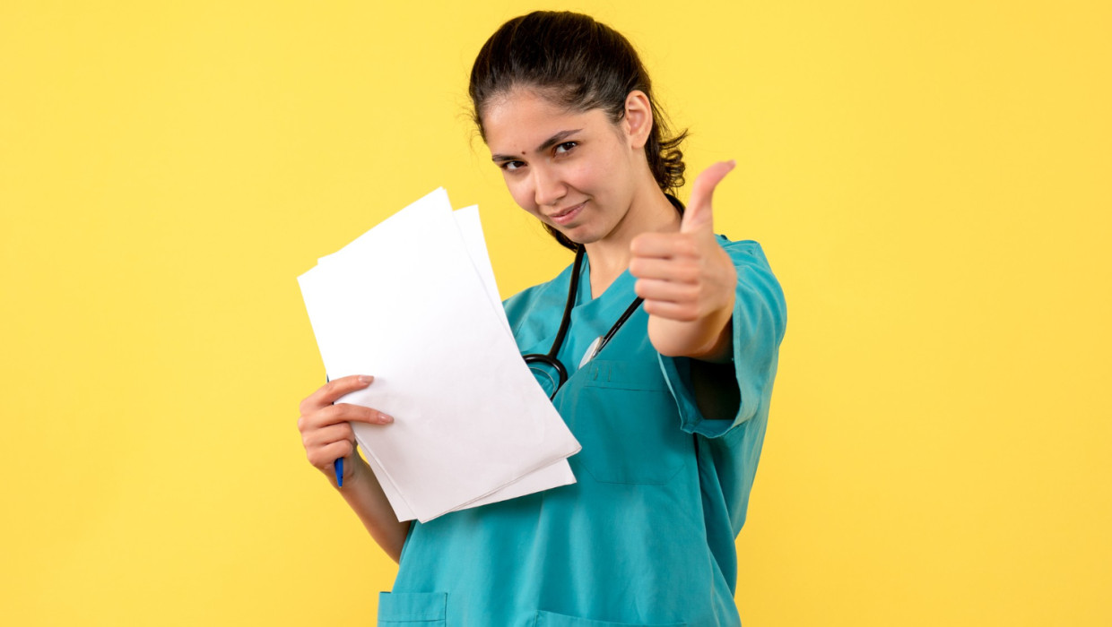 vista frontal doctora documentos que hacen pulgar arriba signo