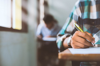 primer plano estudiantes que escriben leen hojas respuestas de examen