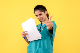 vista frontal doctora documentos que hacen pulgar arriba signo